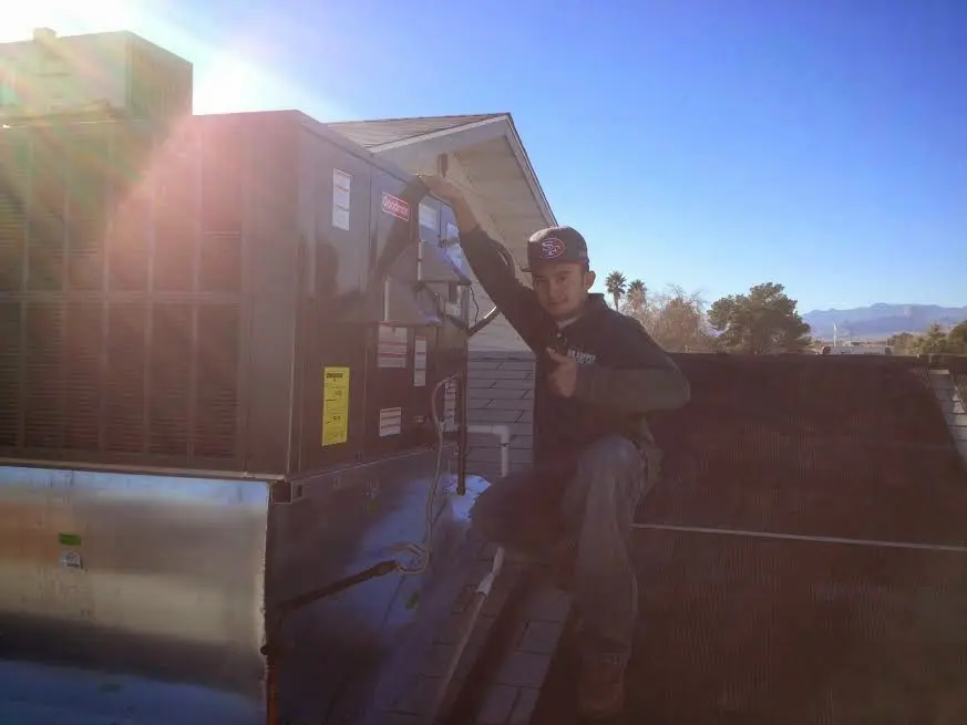 HVAC technician performing Air Duct Cleaning on a rooftop unit in Cheviot